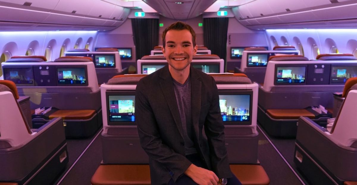 A person standing in a business class airplane cabin