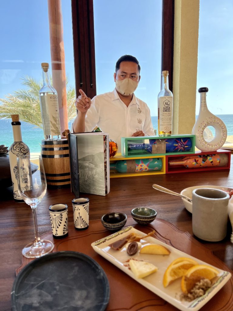 a man pointing to a bottle of liquor