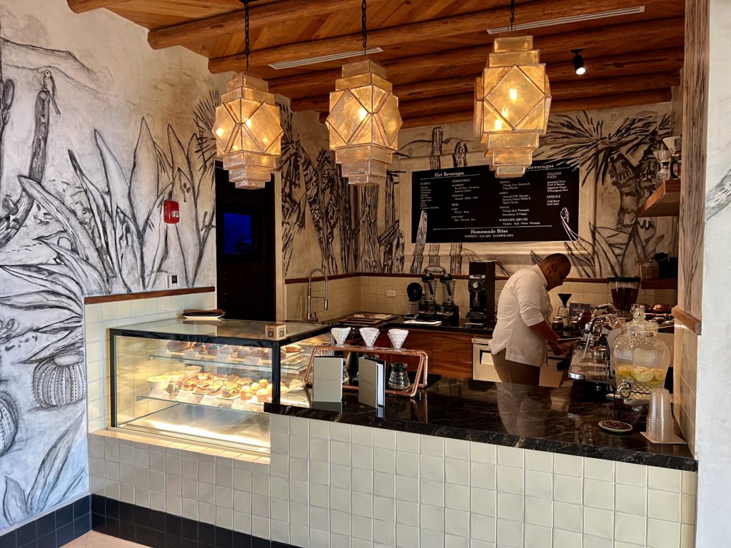 a small cafe with a man working behind the display