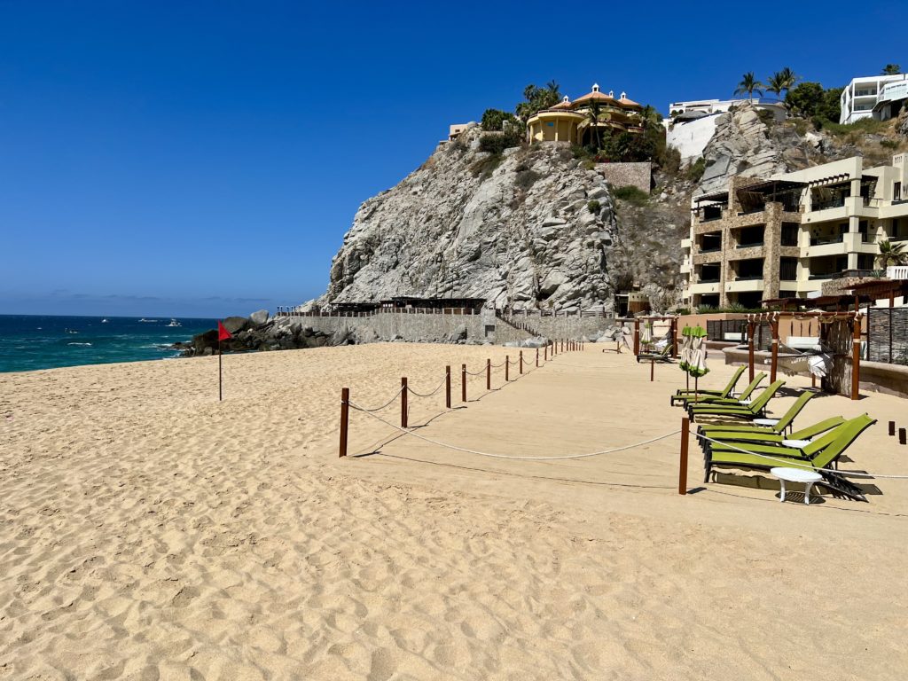 chairs on the beach with a rocky hill behind