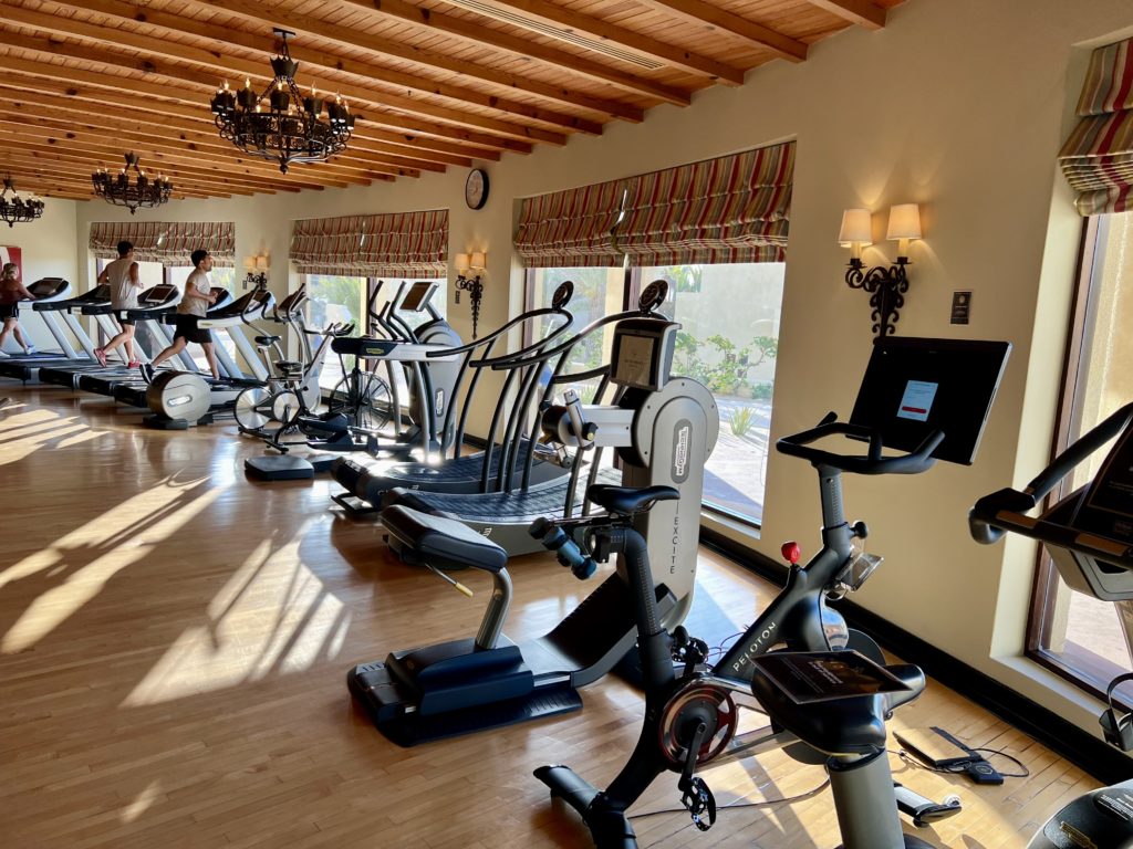 a peloton bike with several other workout machines