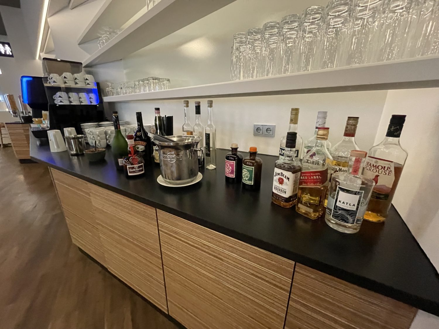 Liquor and glasses on a counter top in an airport lounge. 