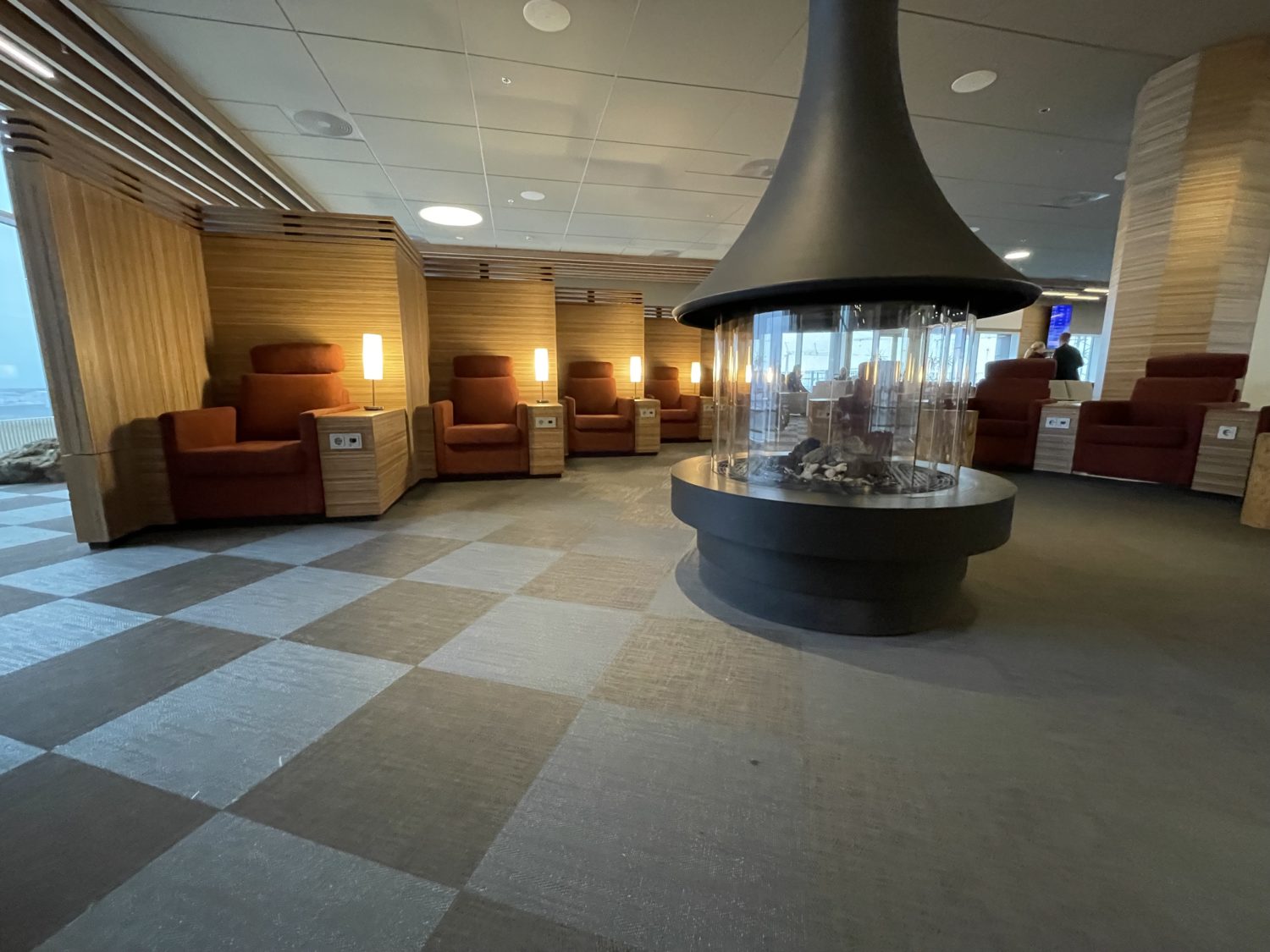No Lie-Flat Seat, No Problem: Icelandair Saga Business Class Still Shines 27 Lounge seating around a fireplace hearth.