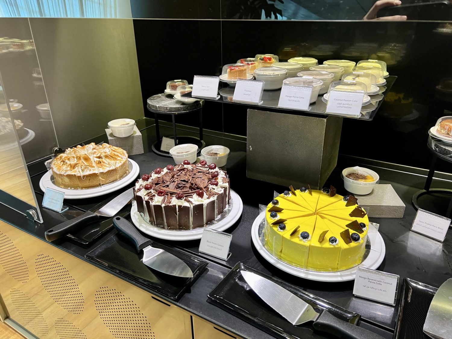 cakes and other desserts on a dining display