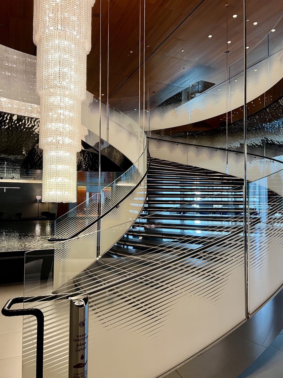 spiral staircase built around a large crystal chandelier