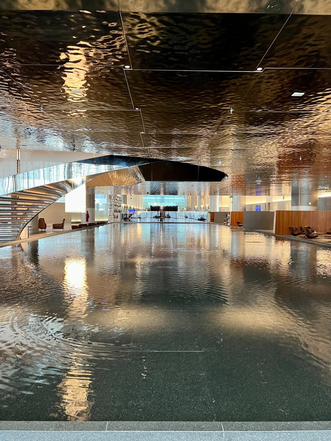 long reflecting water pool with a curving staircase on the side