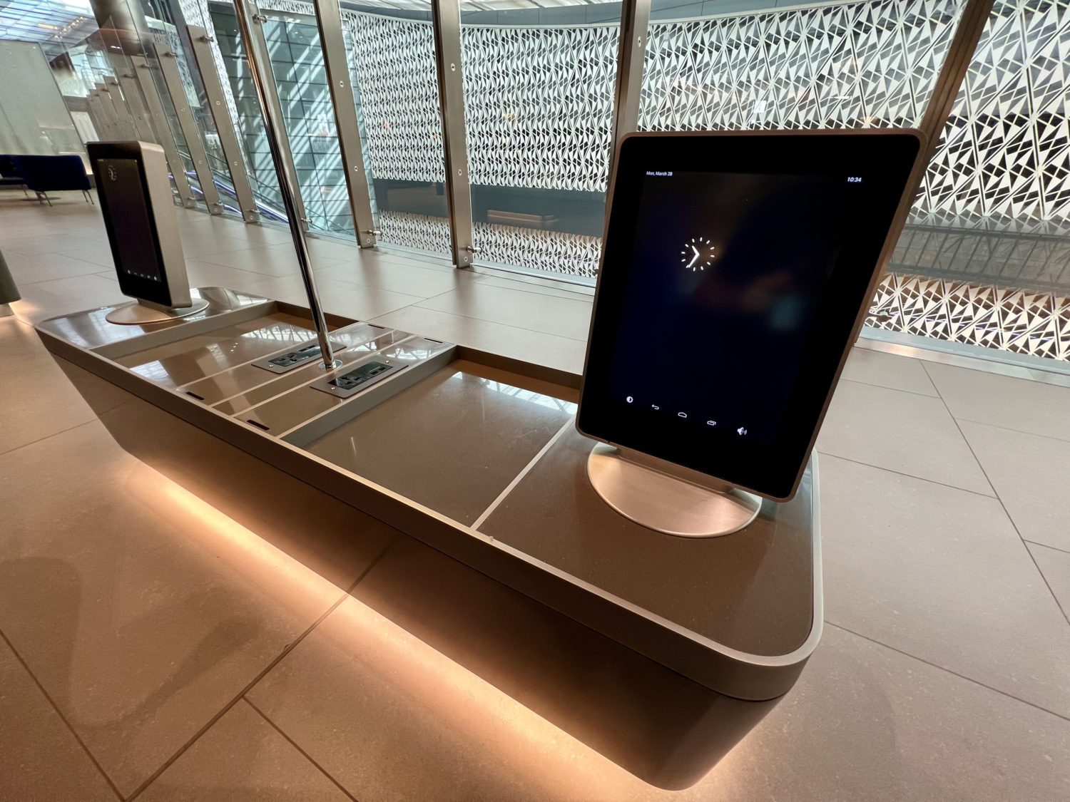 monitor with a clock on top of a small table 