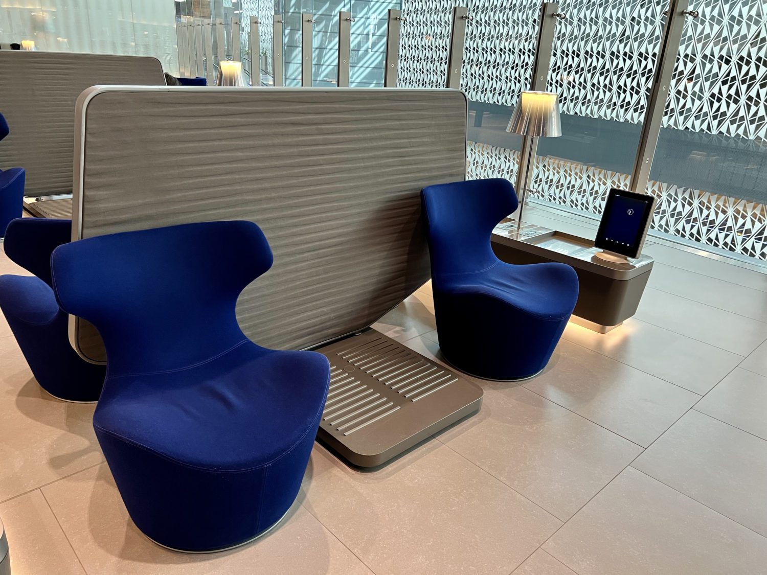 blue armchairs in front of a large gray privacy divider