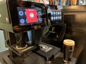 Machine printing face on beer at Guinness factory in Dublin, Ireland