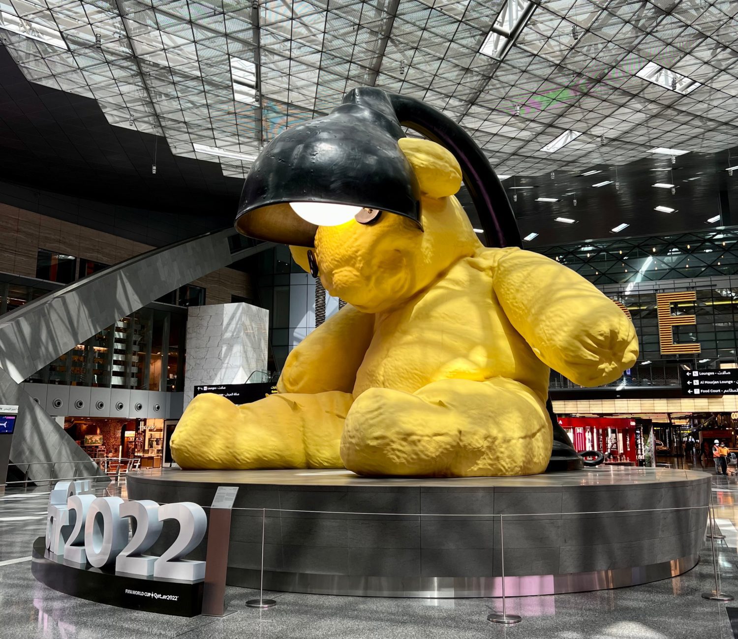 large yellow bear statue with a black lamp coming out of it
