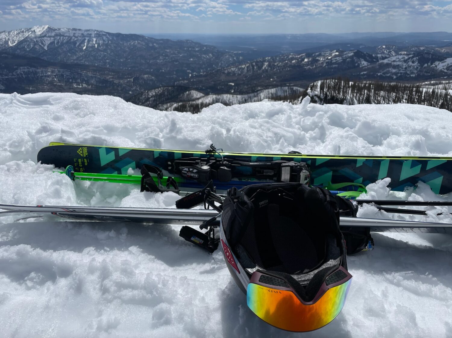 skis and a helmet with goggles on snow with a mountain in the background