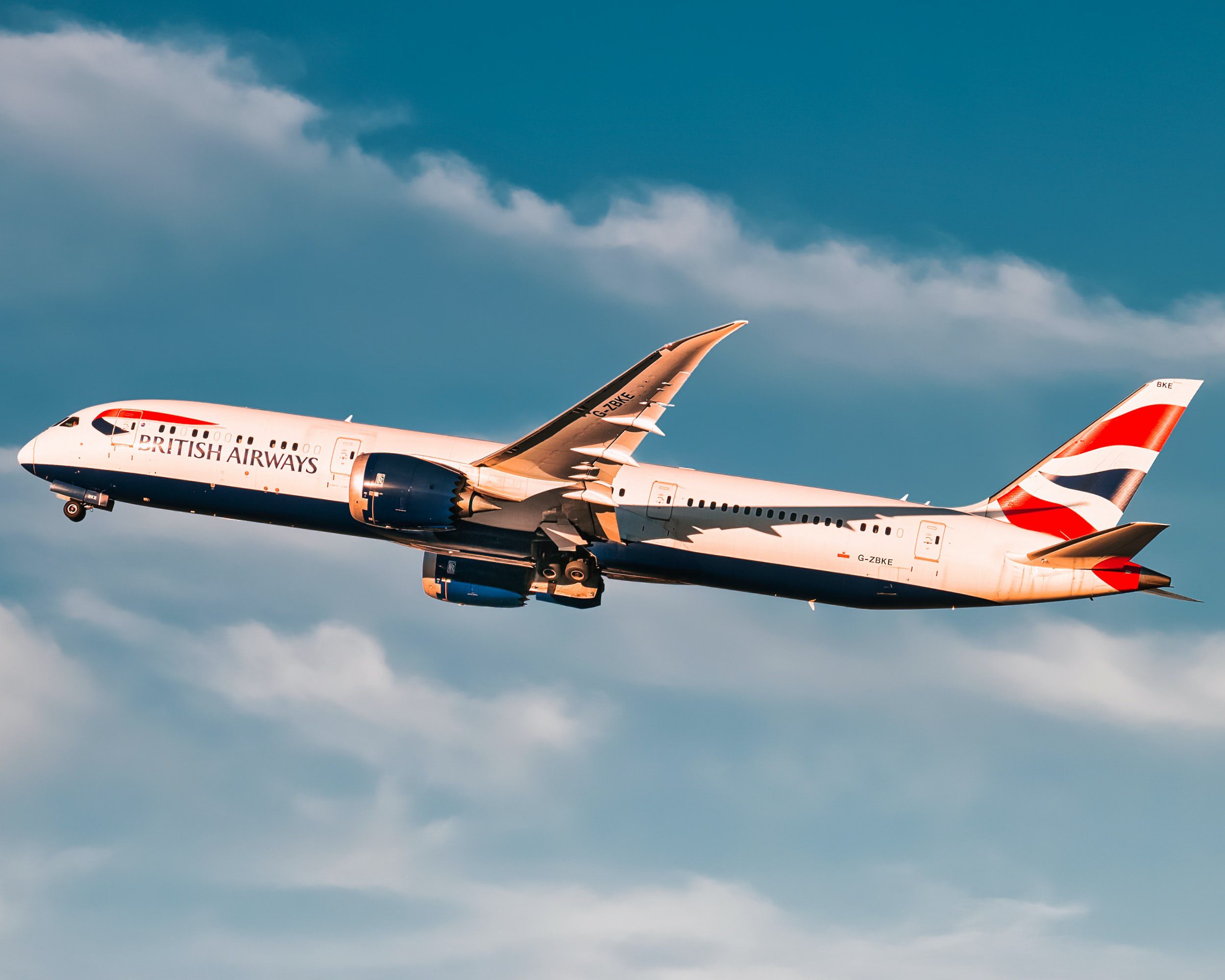 A large passenger jet flying through a cloudy blue sky