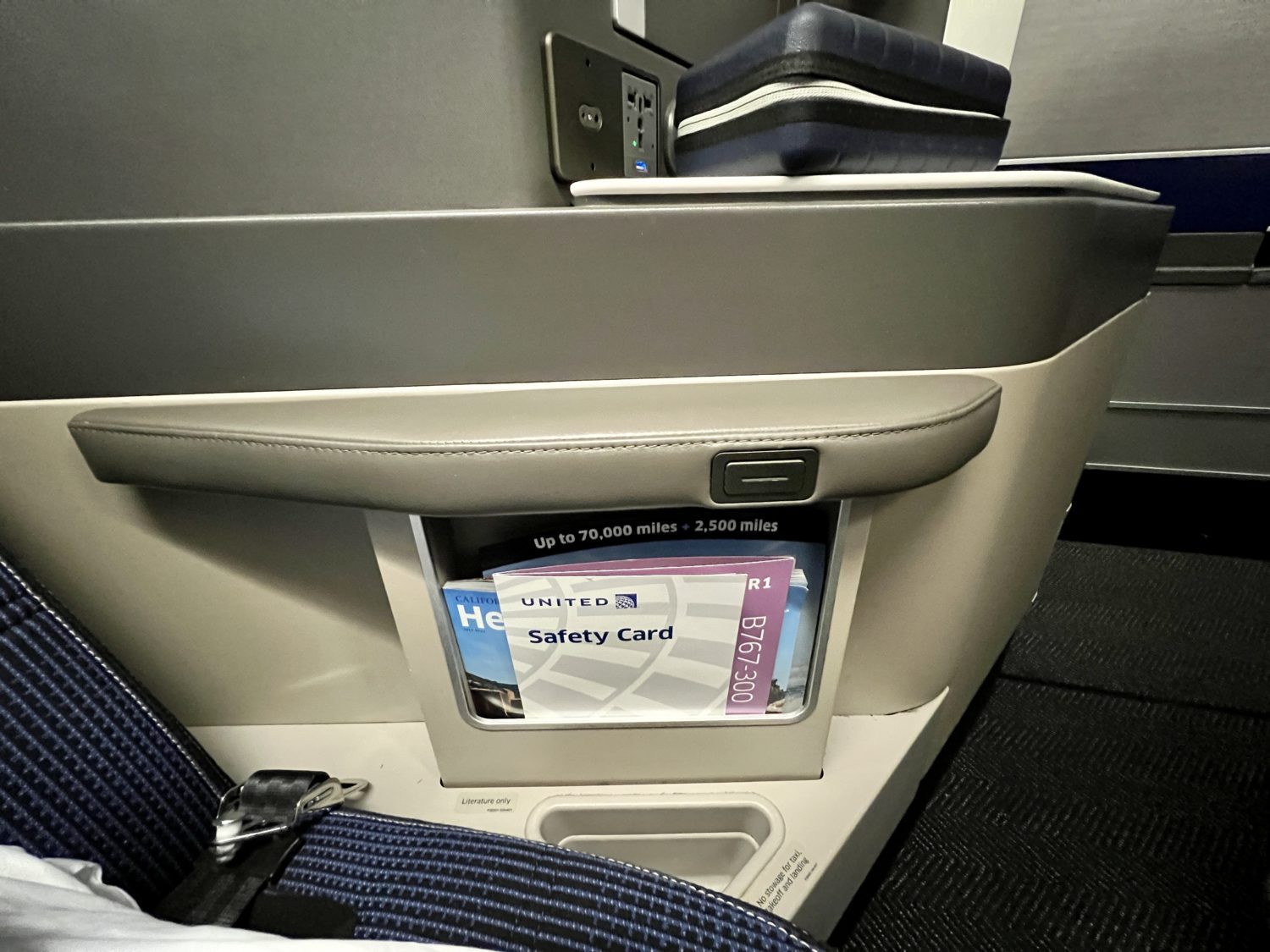 plane armrest with literature pocket and storage below