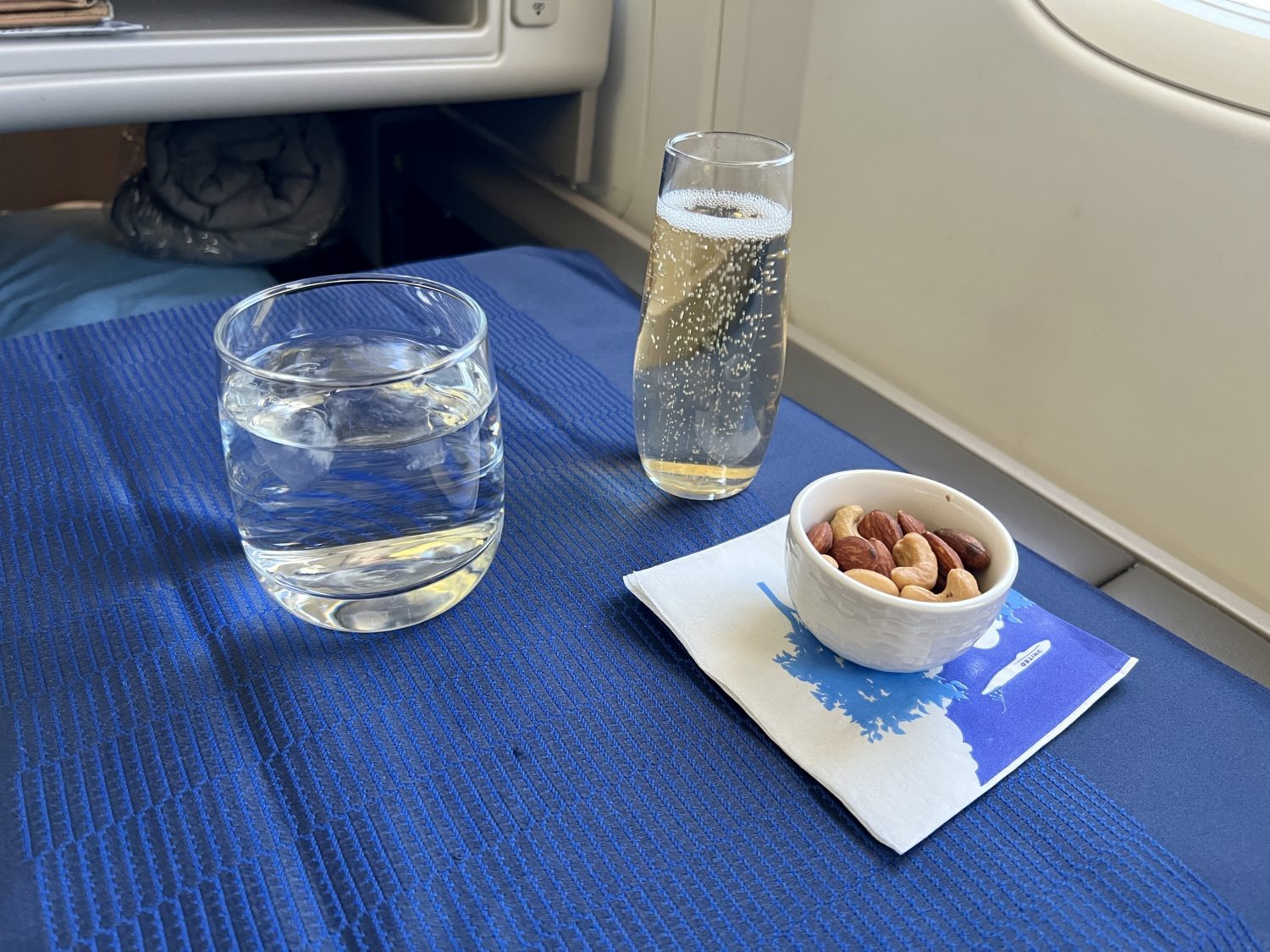 drinks and a ramekin of nuts on a tray