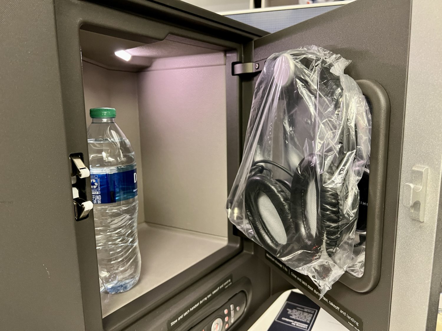 headphones hanging inside a business class storage compartment