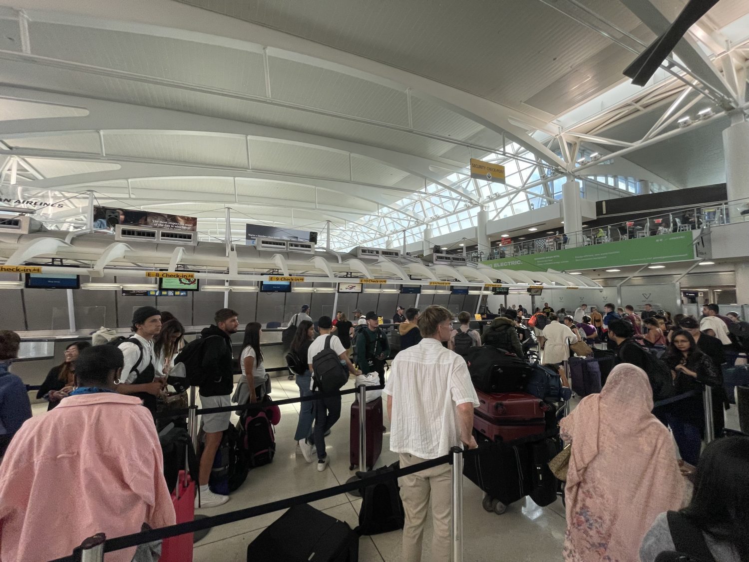 passengers waiting in line to check in at an airport