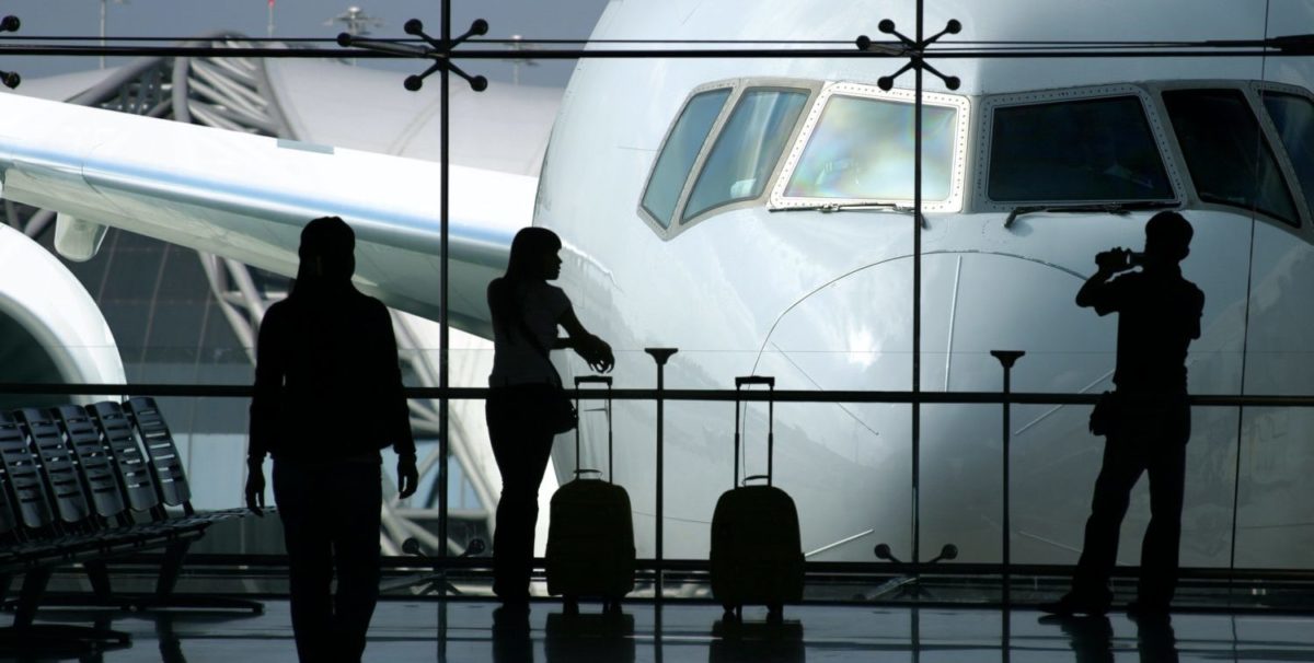 A group of people standing around a plane