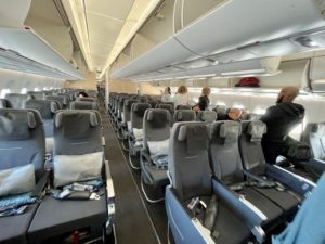 The inside of the economy cabin in an Airbus A350 airplane with grey seats. 