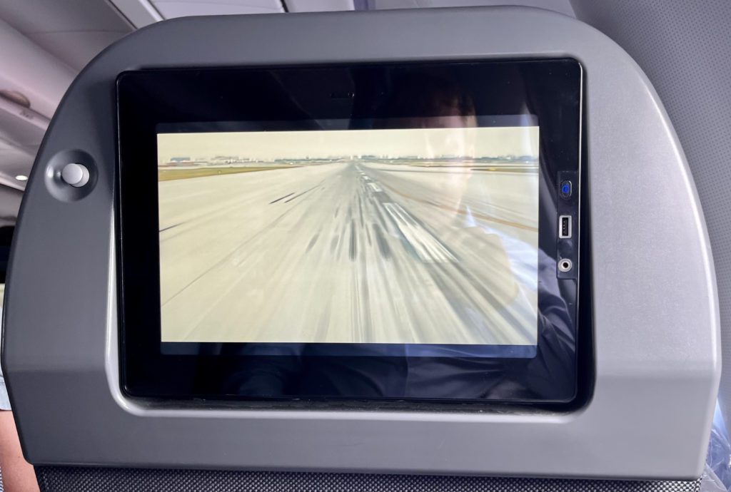 coat hook and tv screen on the back of an airplane seat