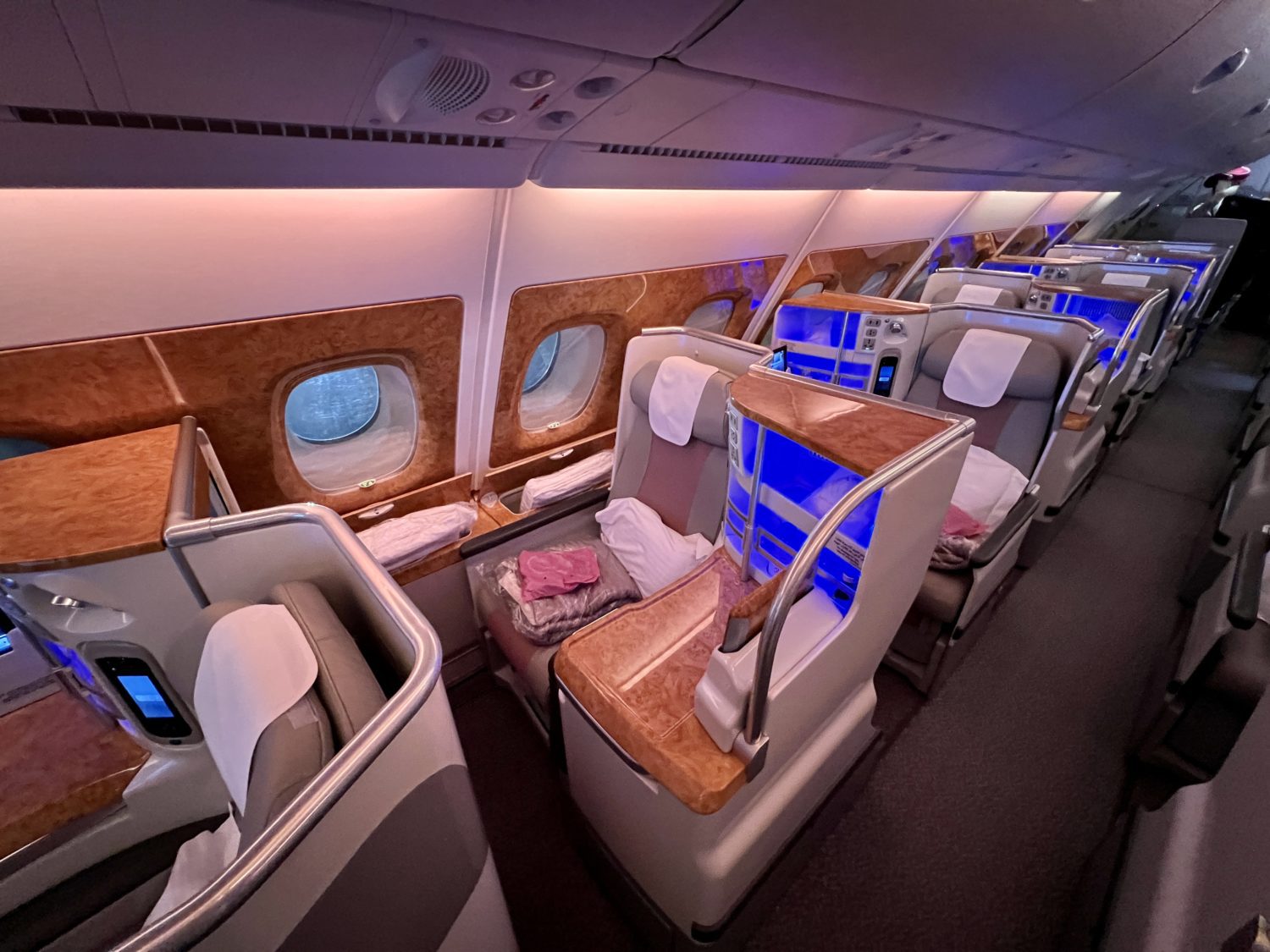 a row of business class seats along the side of a plane