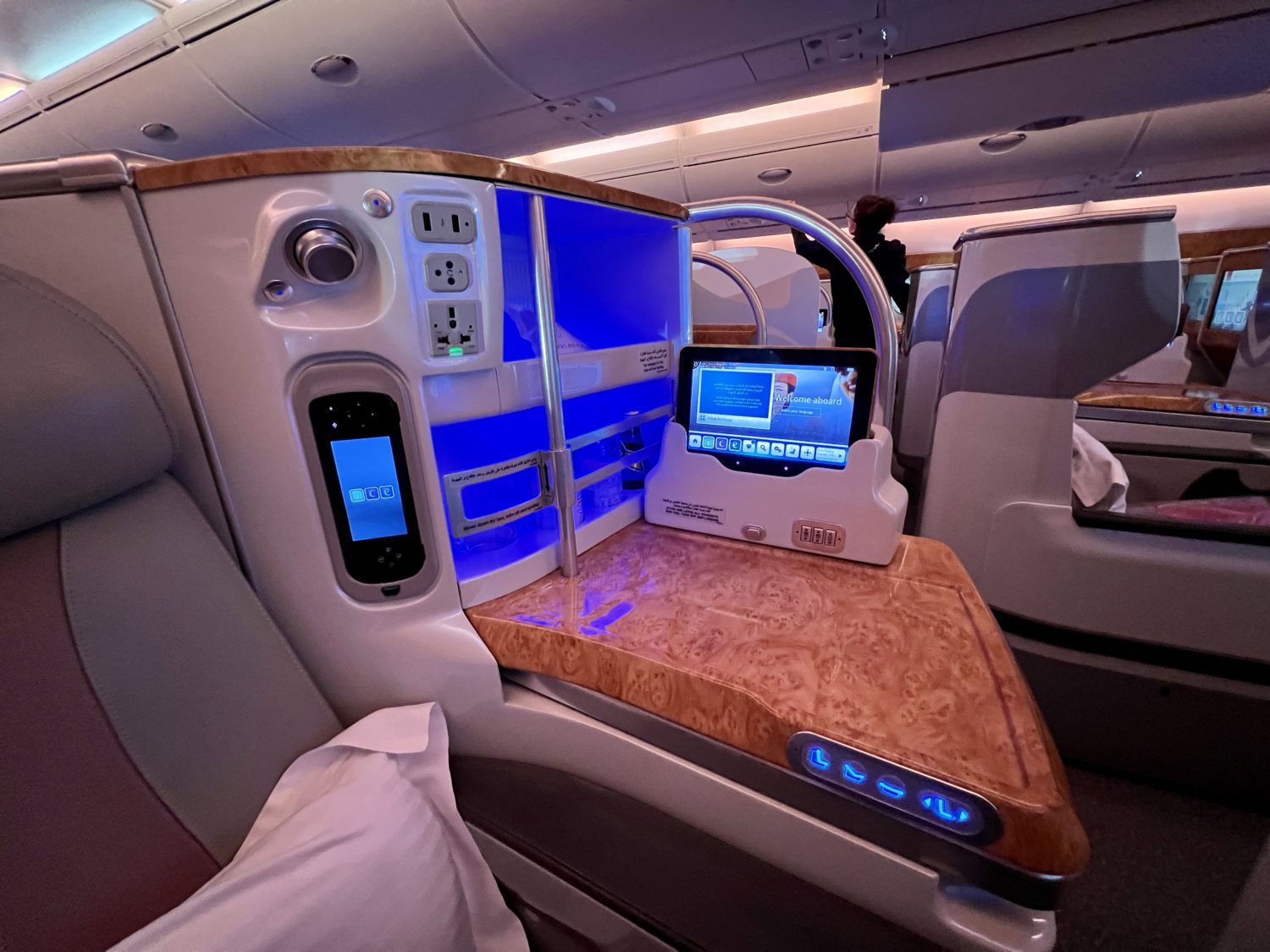 side view from a business class seat showing a blue storage console and tablet