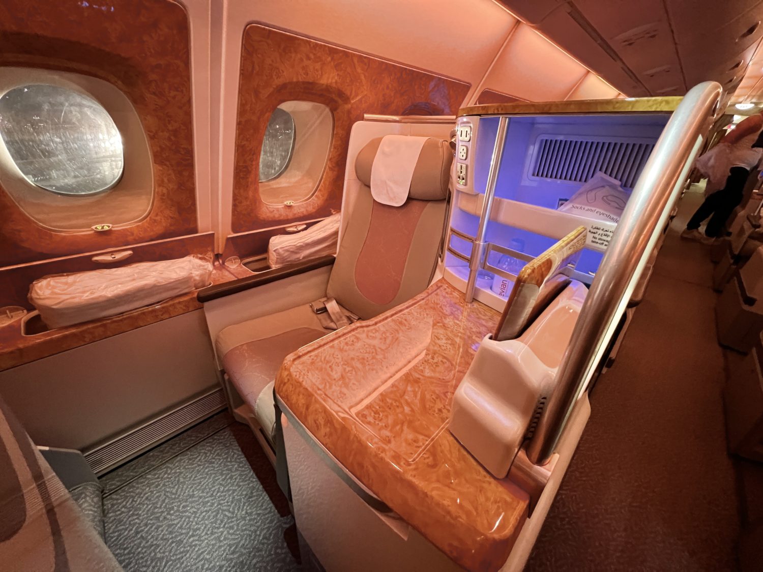 a single emirates business class seat along the side of the plane with windows