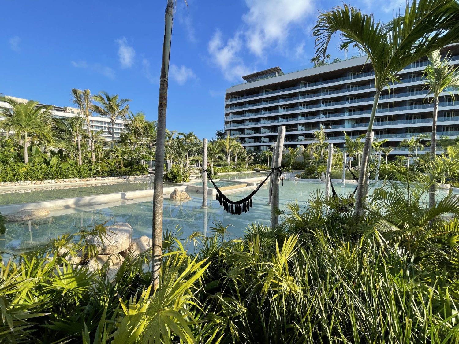 hot tubs in the middle of the pool with tropical plants all around