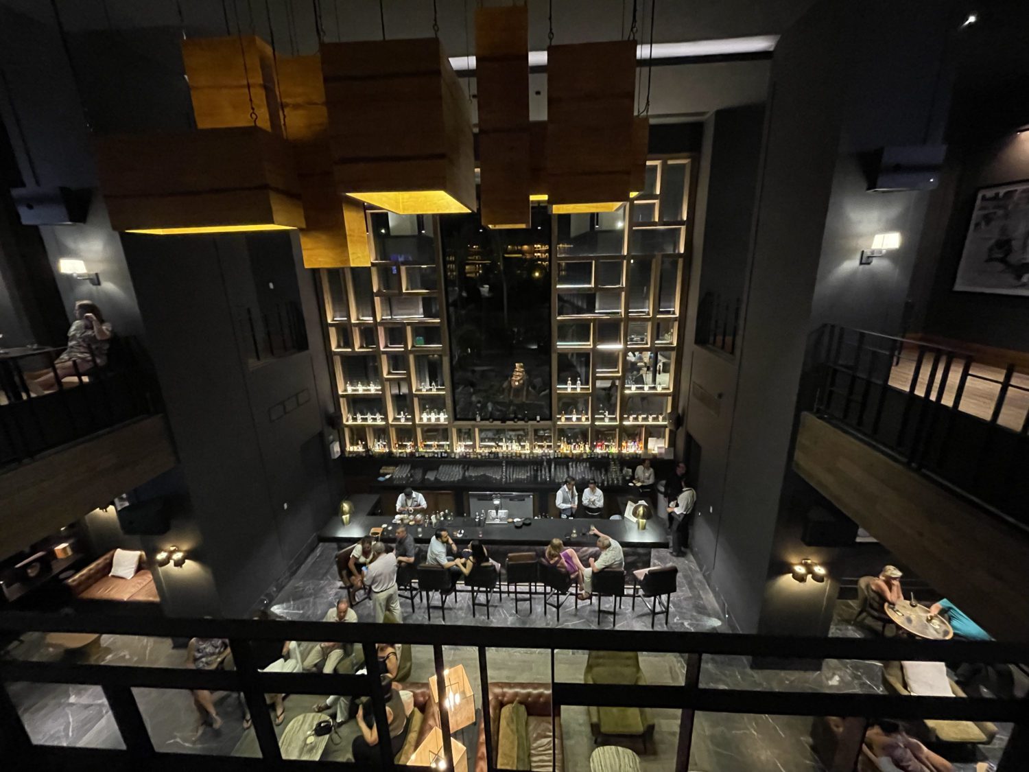 view looking down on a sports bar at a hotel with moody lighting and decor