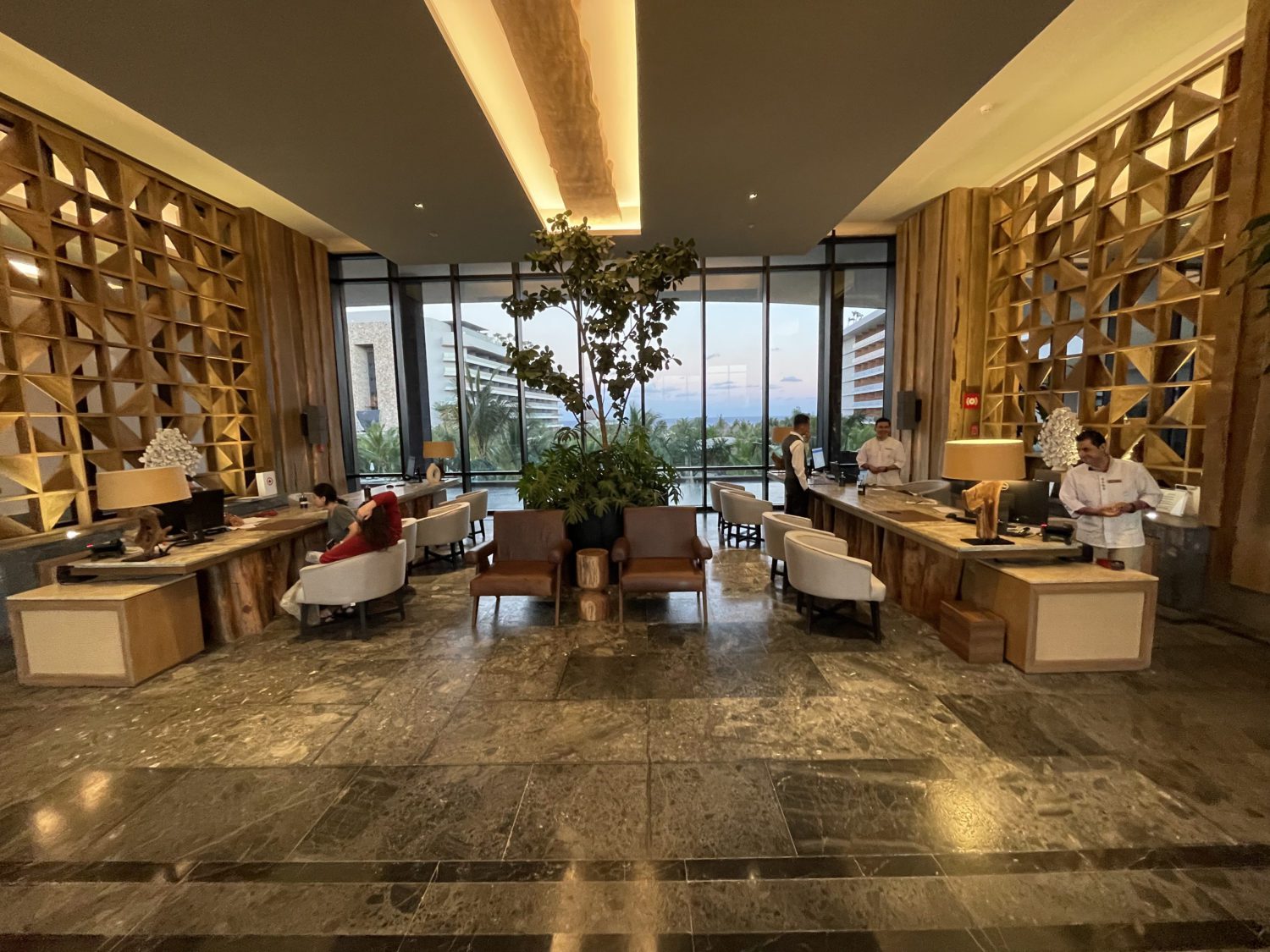 hotel lobby with armchairs in front of the check in and concierge desks 