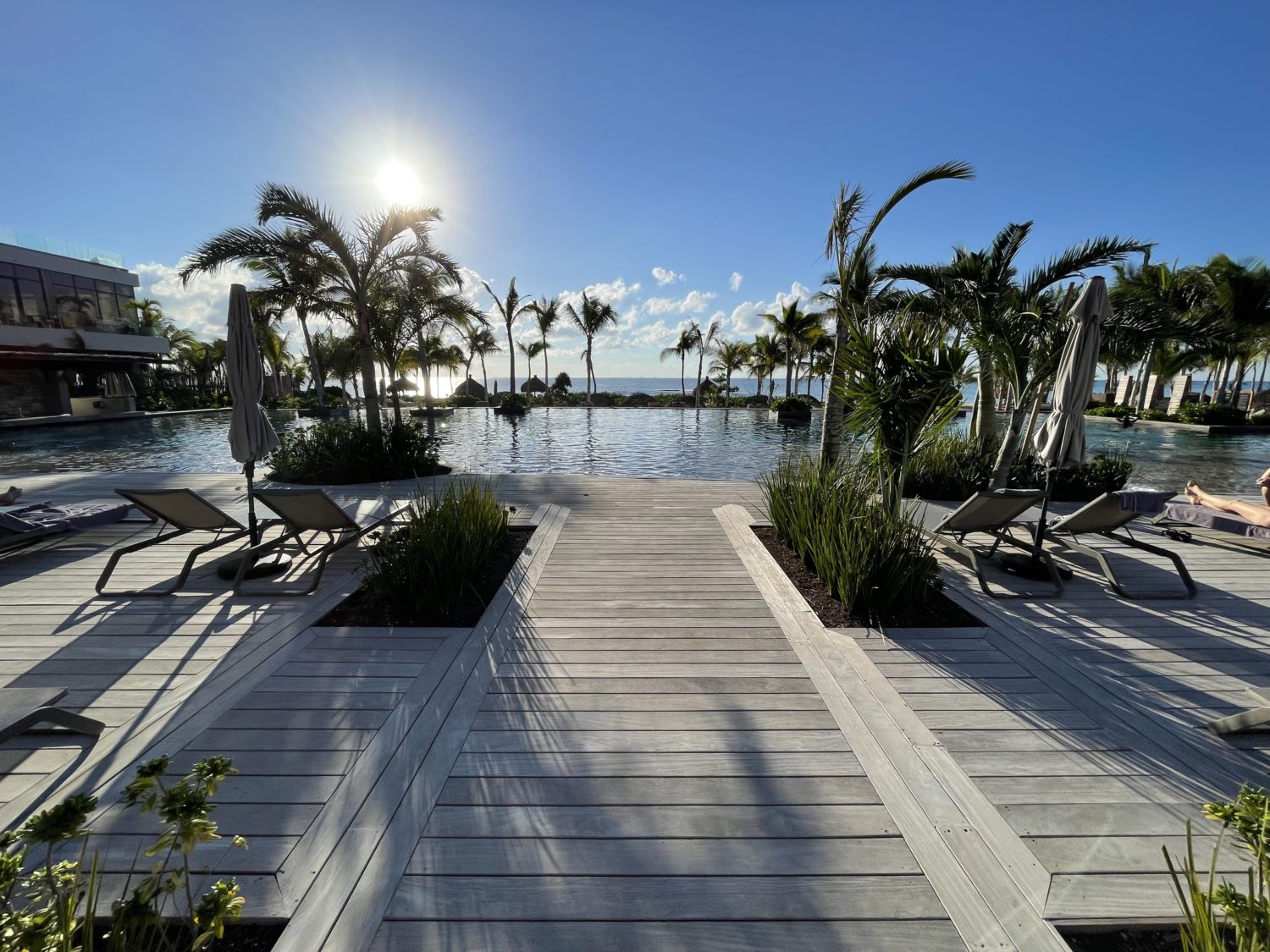 main pool with a deck and a view of the ocean. 