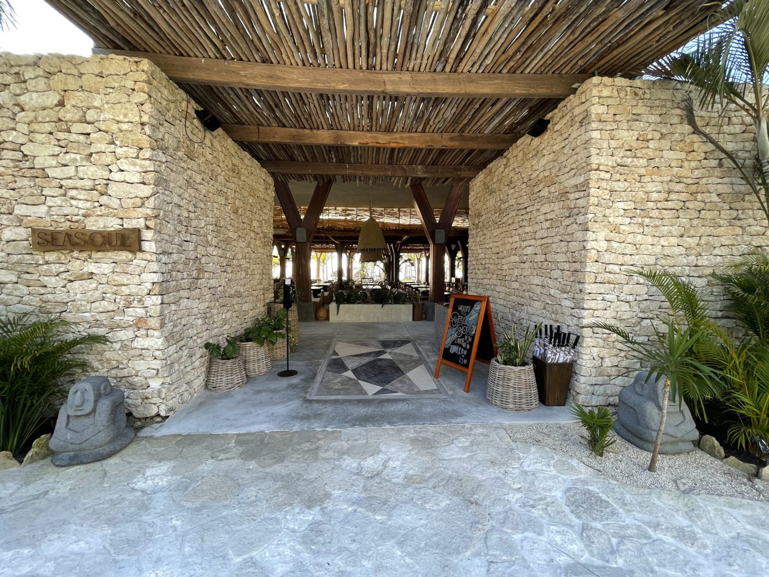 outdoor restaurant entrance flanked by two rock walls