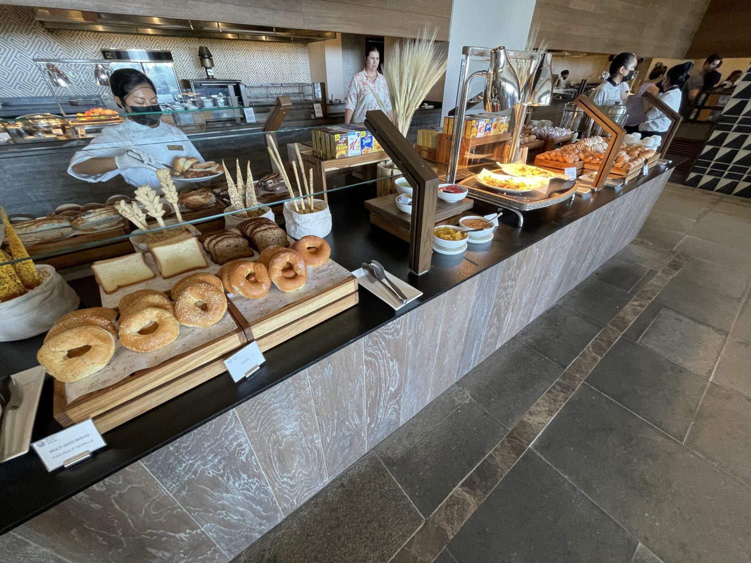 donuts, bagels, bread and other baked goods at a hotel breakfast buffet