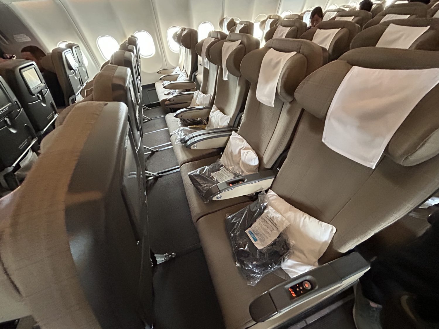 A row of brown airplane seats onboard a SWISS A330 aircraft. 