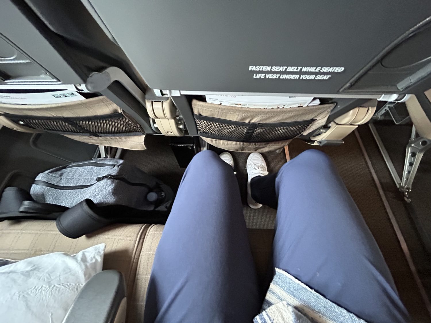 The legroom on an economy seat with a man's legs in it. 