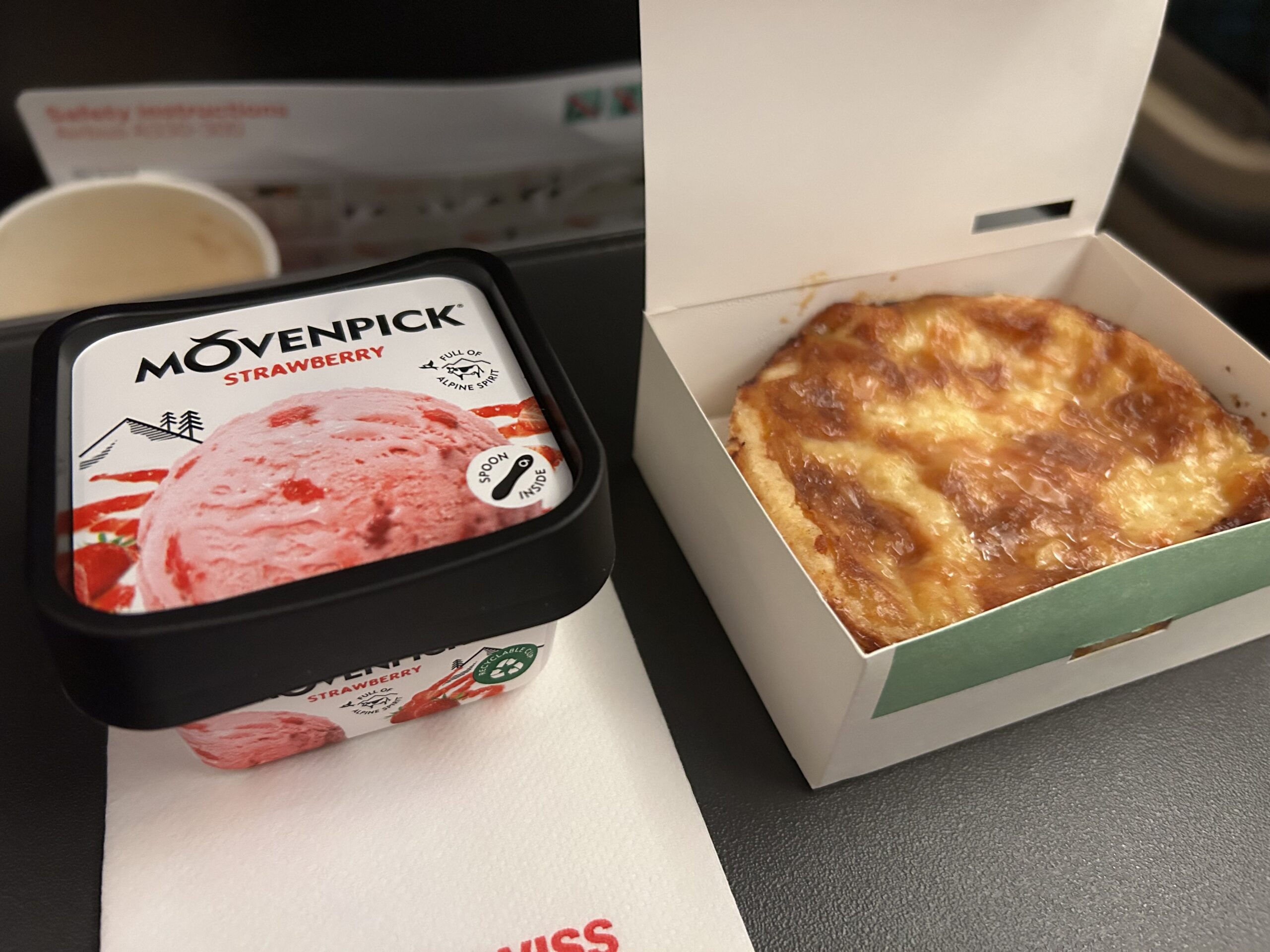 Ice cream and a pastry on a tray table. 