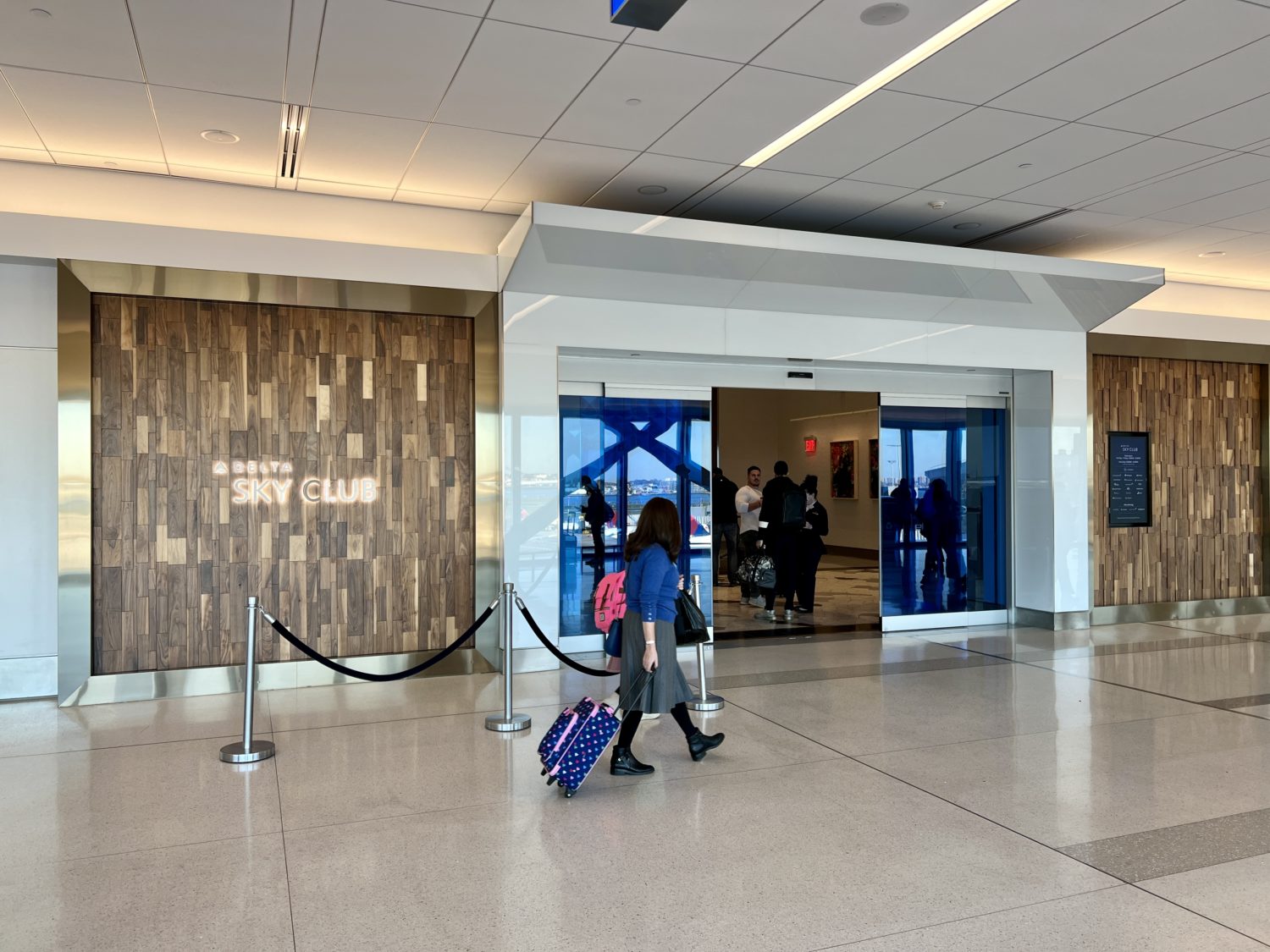 entrance to delta sky club doors with a traveler standing outside