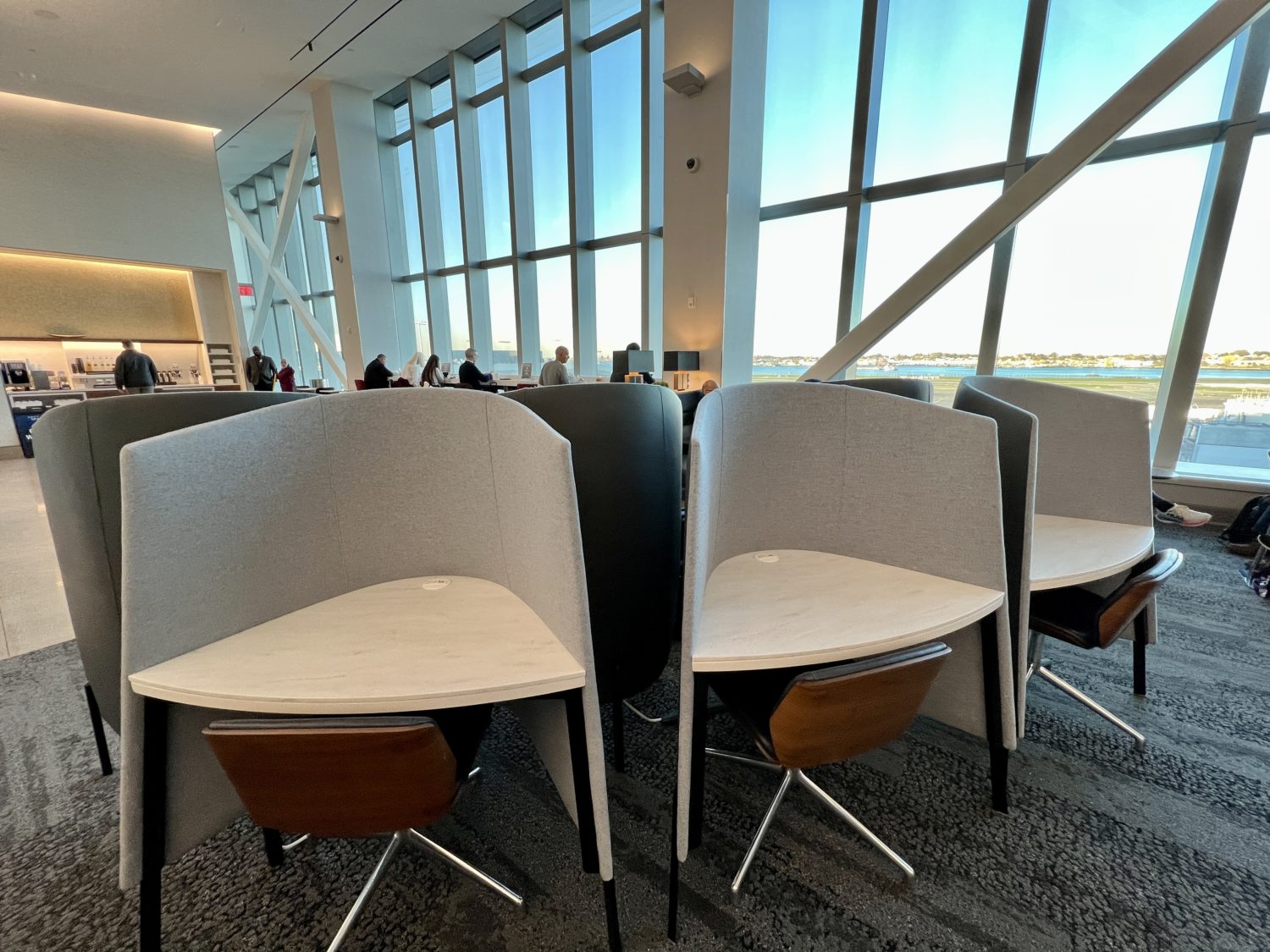 three cubicle desks with wooden chairs