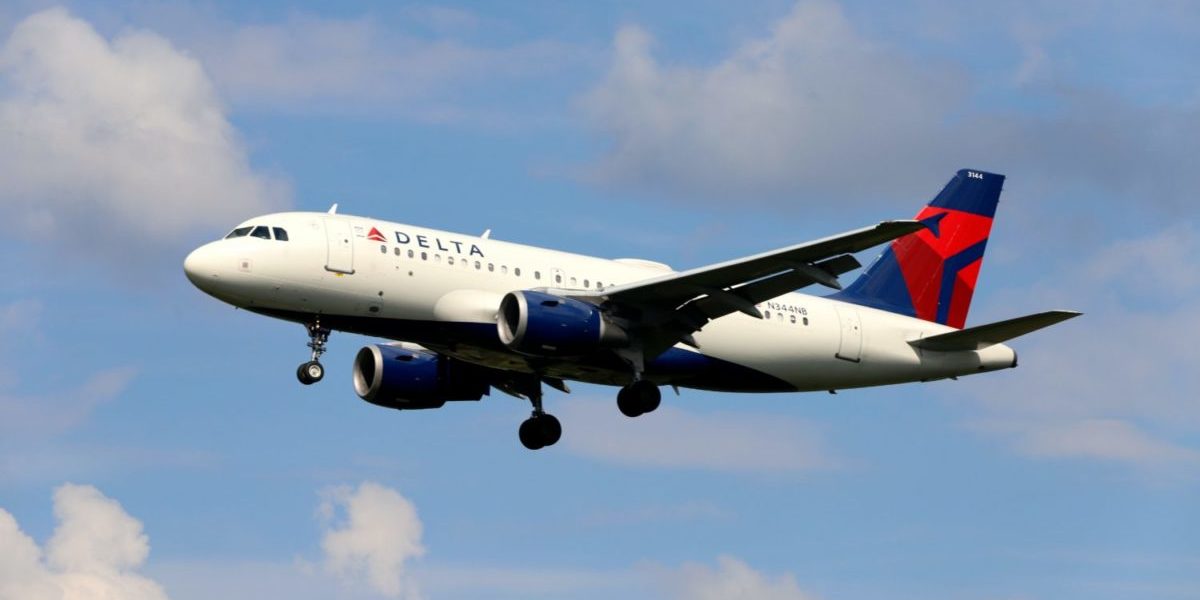 A large passenger jet flying through a cloudy blue sky