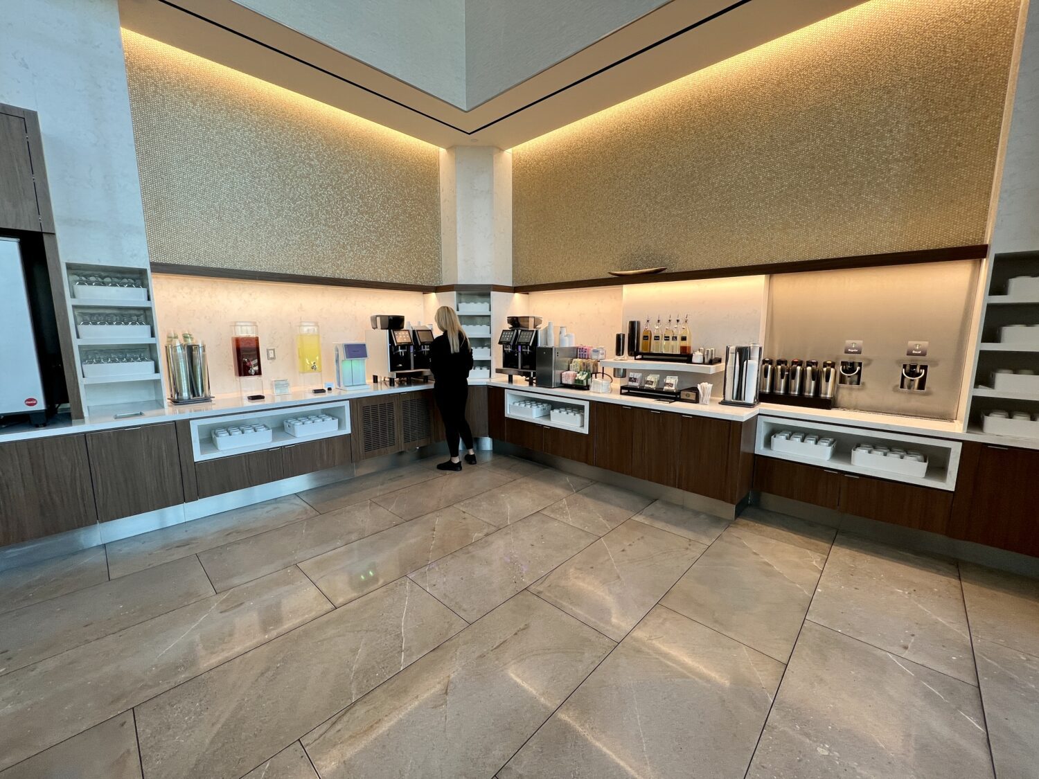 airport lounge guest making a coffee at a drink station