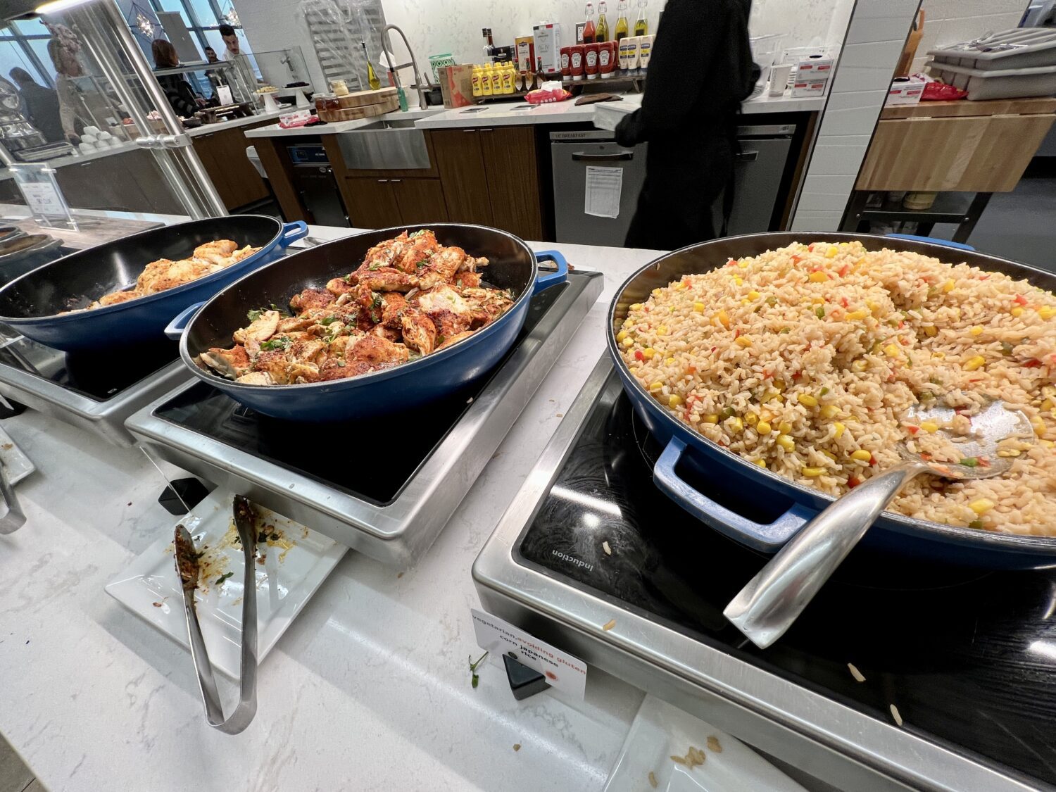 Large containers of rice and chicken on hot plates