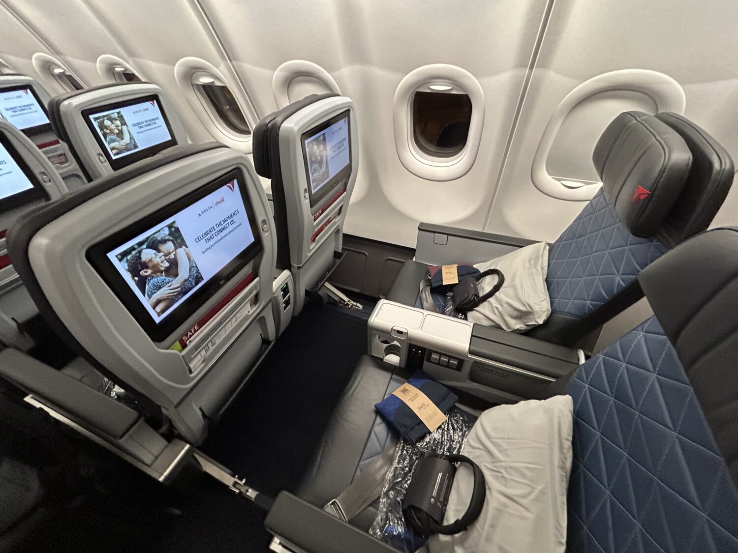 An overhead look at premium economy seats on a Delta Airbus airplane