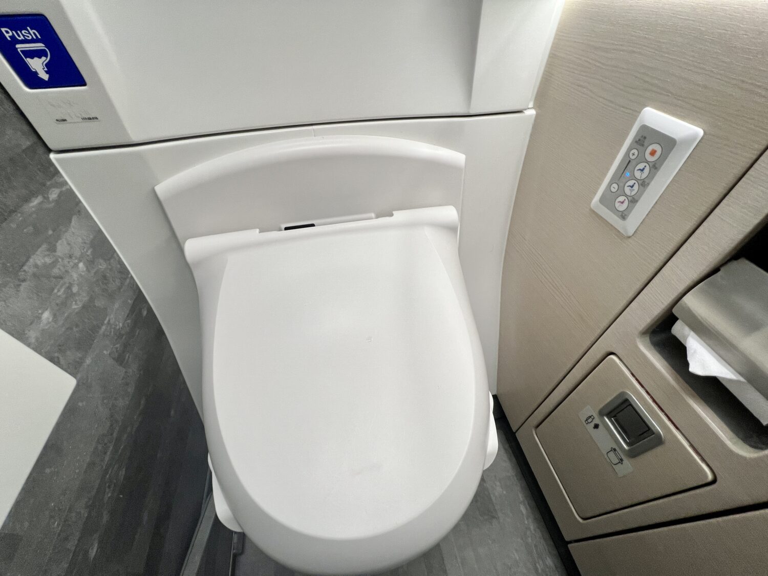toilet on a plane with a bidet control