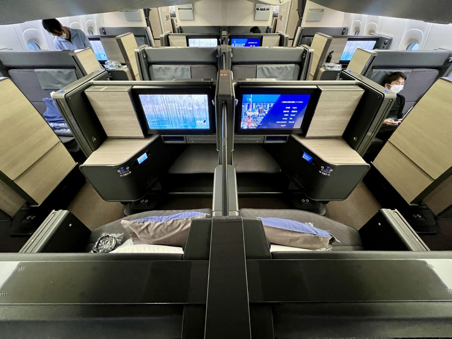 side by side business class seats with large tv screens