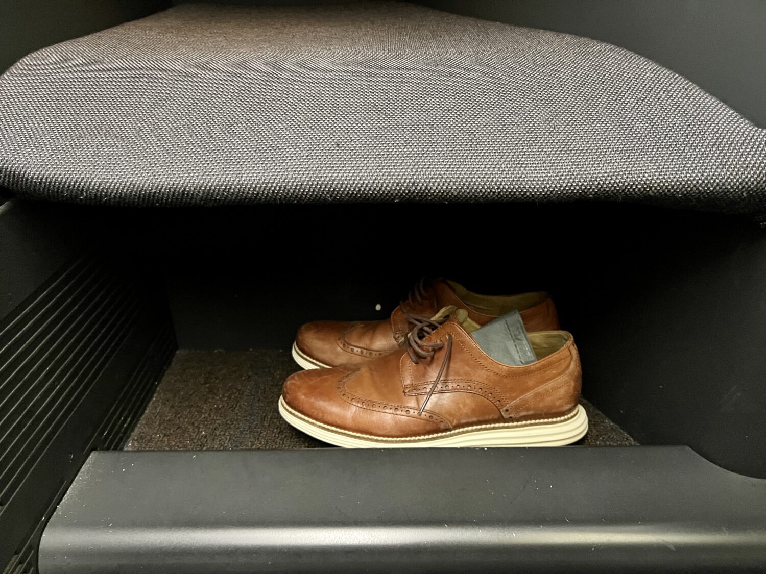 shoes underneath a business class seat footwell