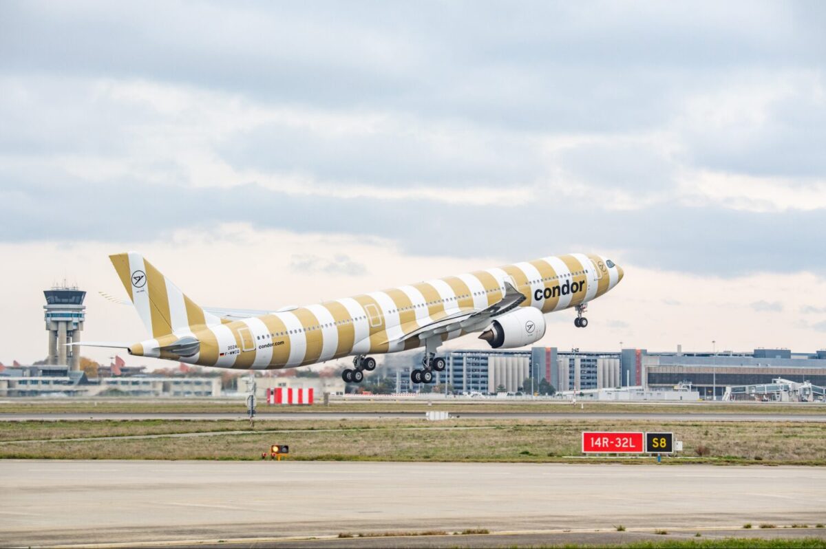 a yellow and white striped condor airlines airplane taking off