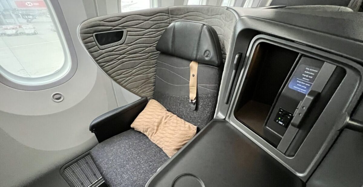 Turkish Airlines business class seat in grey with grey interiors and a brown pillow and seatbelt strap. 