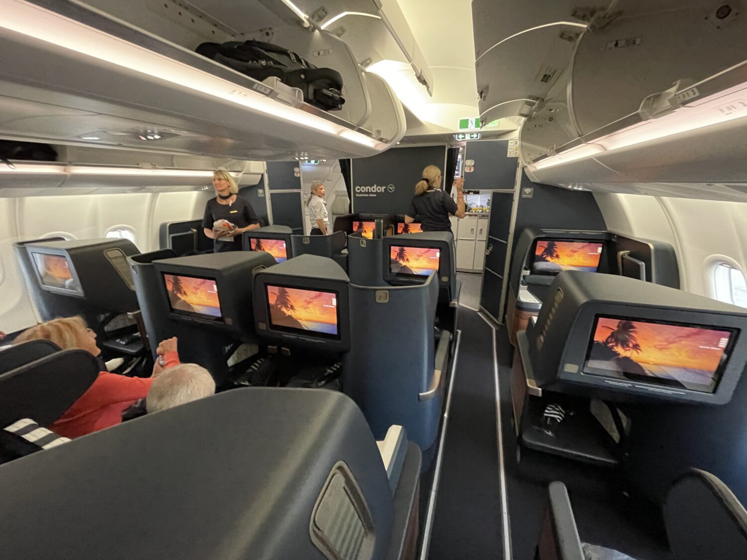 rows of business class seats and flight attendants 