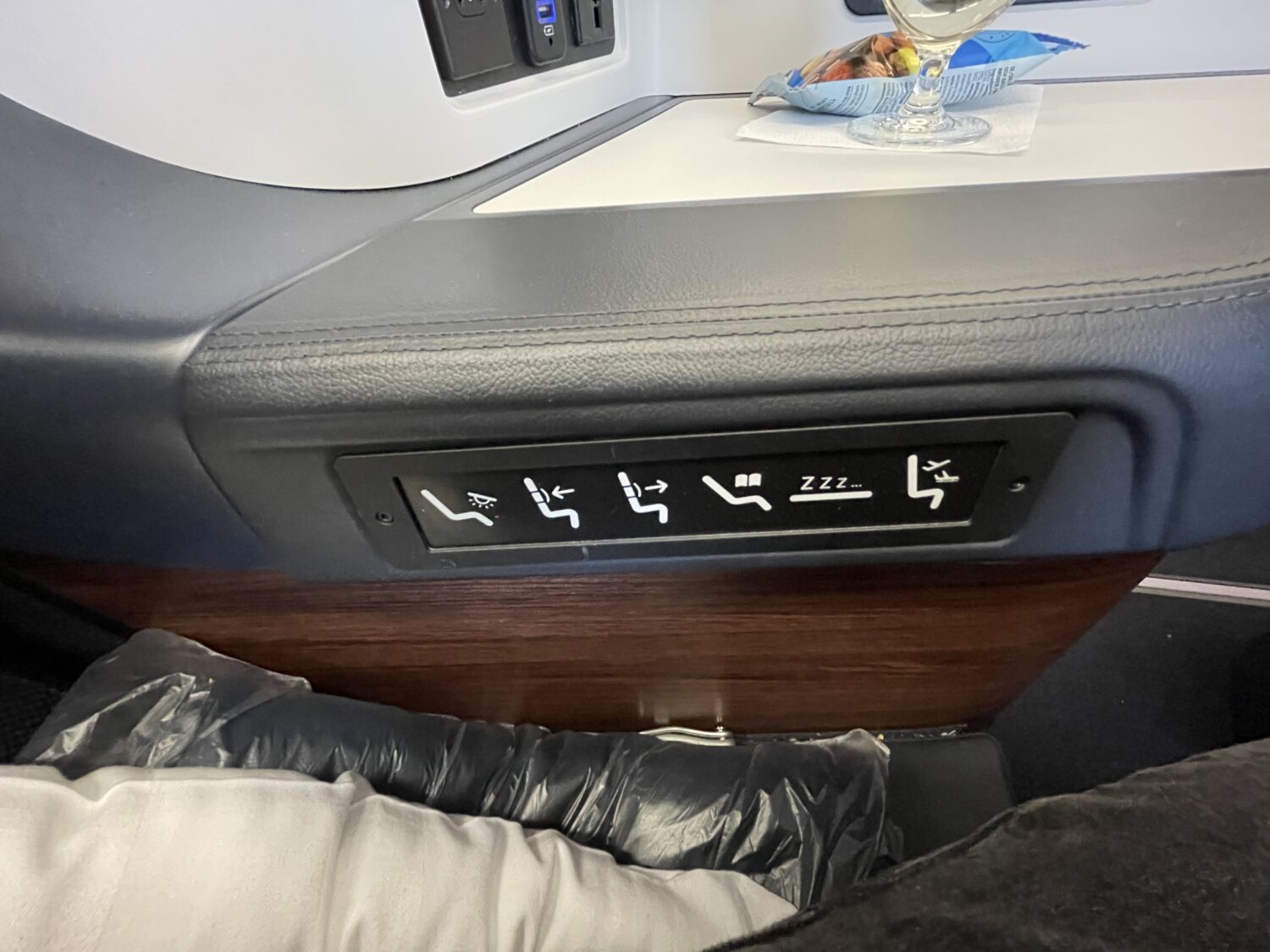 controls on the armrest of an airplane business class seat