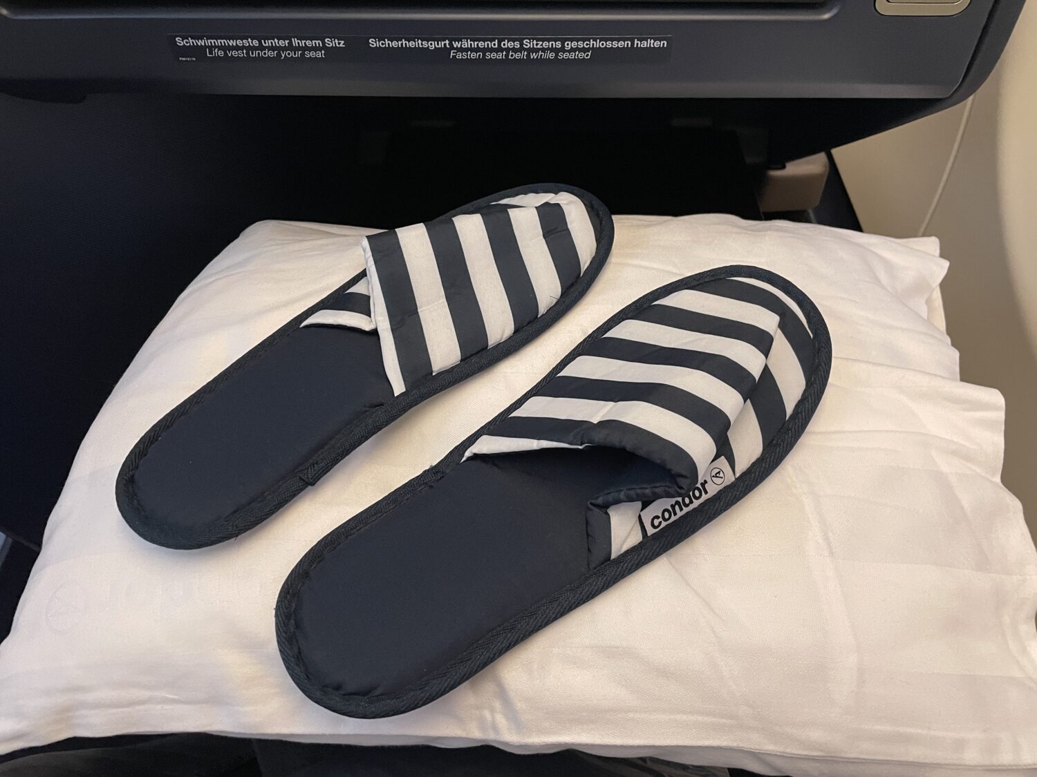 a pair of navy blue and white striped slippers on a pillow 