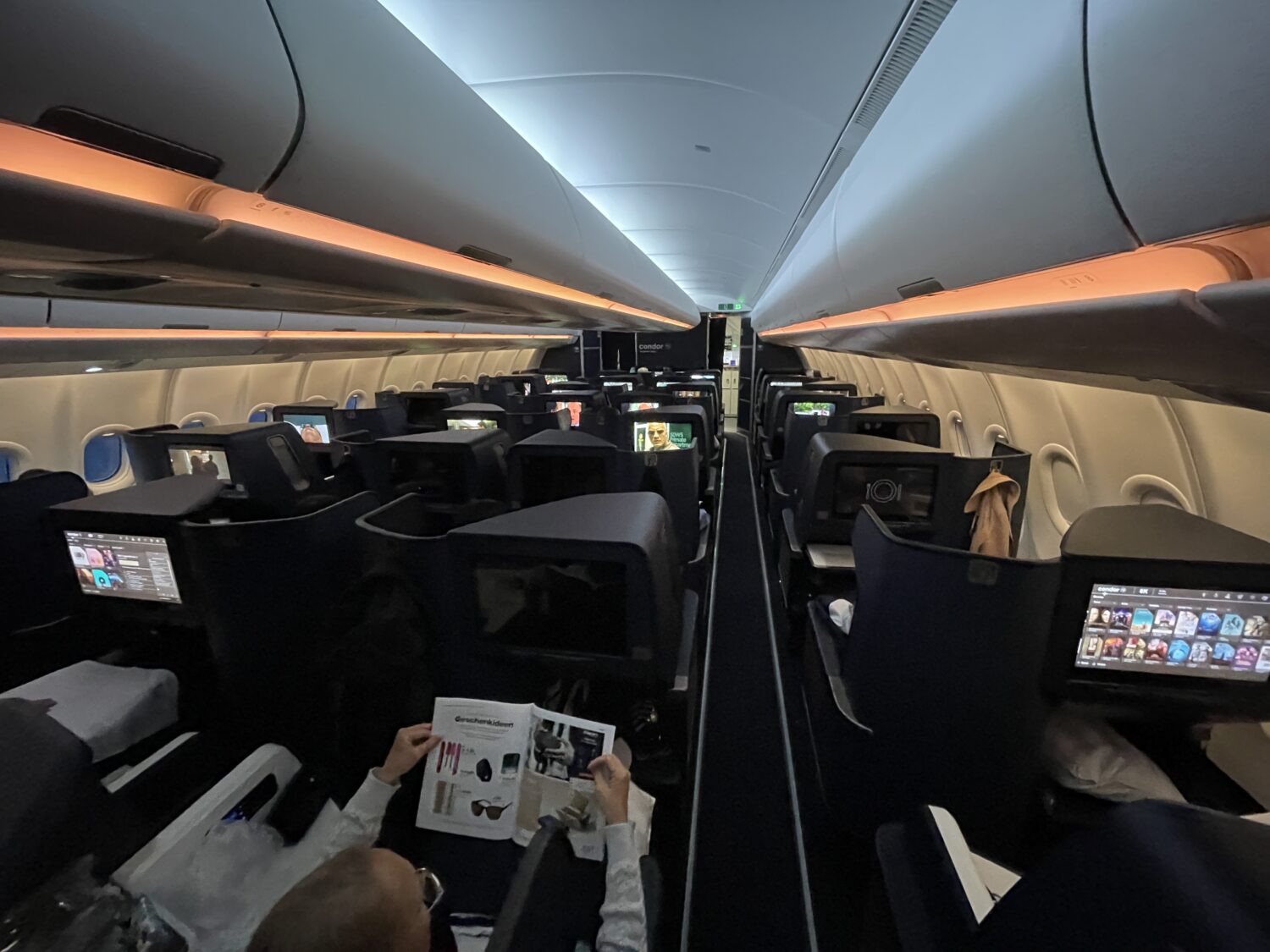 rows of business class seats with orange overhead lights